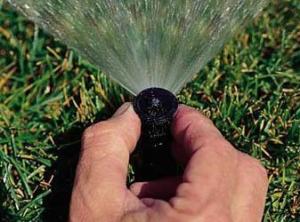Pembroke Pines FL sprinkler repair tech calibrates a sprinkler head