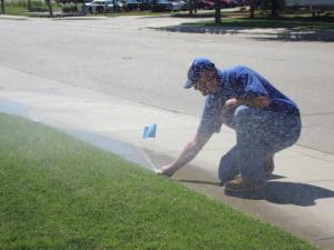 a Pembroke Pines sprinkler repair specialist adjusts a new Rain Bird pop up installation